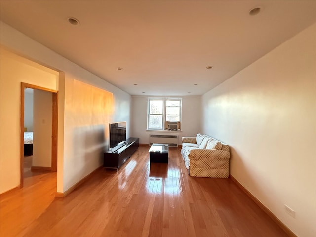 unfurnished living room with radiator, light wood-type flooring, and cooling unit