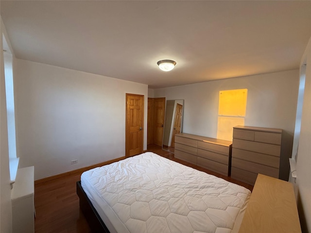 bedroom with dark hardwood / wood-style flooring