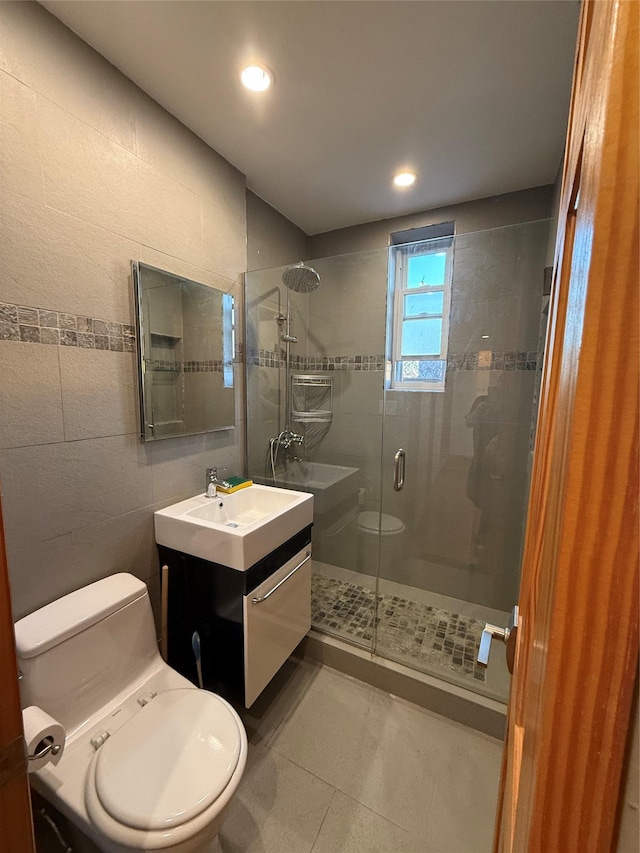 bathroom featuring vanity, toilet, and a shower with door