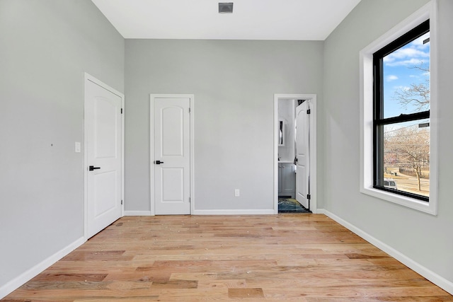 unfurnished bedroom featuring light hardwood / wood-style flooring and ensuite bath