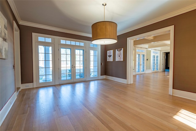 empty room with ornamental molding, french doors, and light wood-type flooring