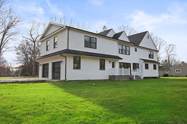 rear view of property featuring a garage and a yard