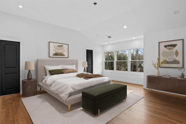 bedroom with vaulted ceiling and light hardwood / wood-style floors