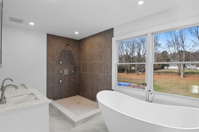 bathroom featuring a healthy amount of sunlight, vanity, and separate shower and tub