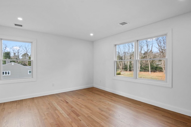 spare room with a wealth of natural light and light wood-type flooring