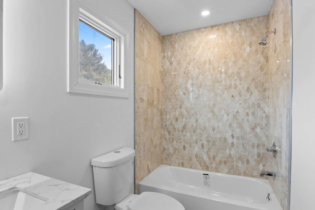 full bathroom featuring tiled shower / bath combo, vanity, and toilet