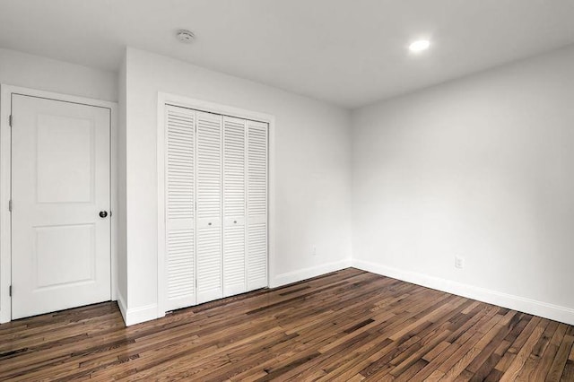 unfurnished bedroom featuring dark wood-type flooring and a closet