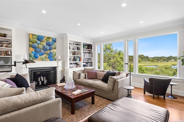 living room featuring crown molding, built in features, and light hardwood / wood-style flooring