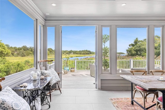 sunroom with a water view and wooden ceiling