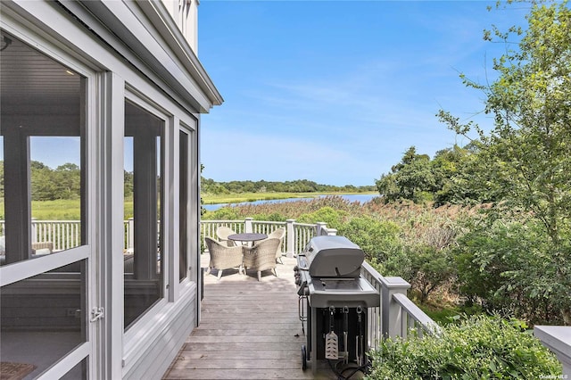 deck featuring a water view and a grill