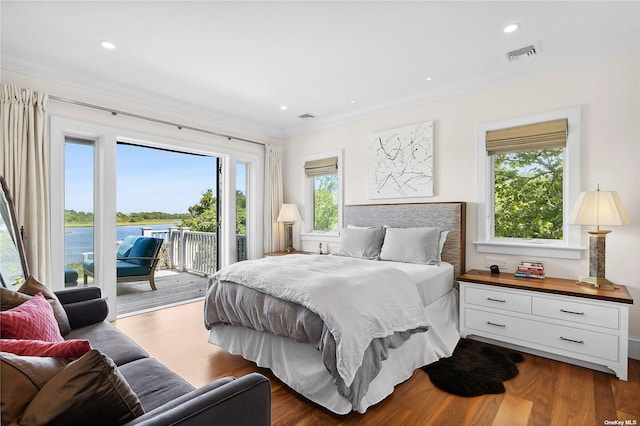 bedroom with dark hardwood / wood-style flooring, access to outside, ornamental molding, and a water view