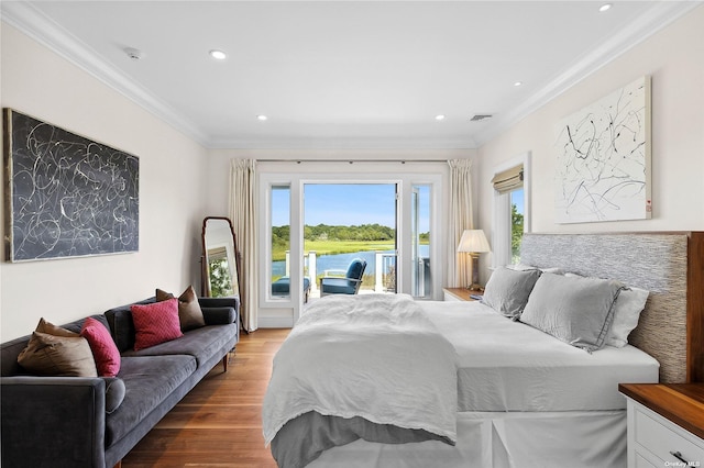 bedroom with a water view, ornamental molding, access to exterior, and hardwood / wood-style floors