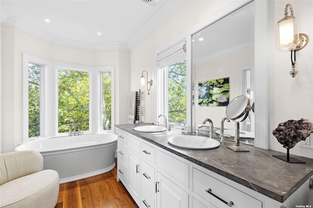 bathroom with vanity, a bathtub, wood-type flooring, and ornamental molding