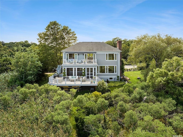 back of property with a wooden deck and a balcony