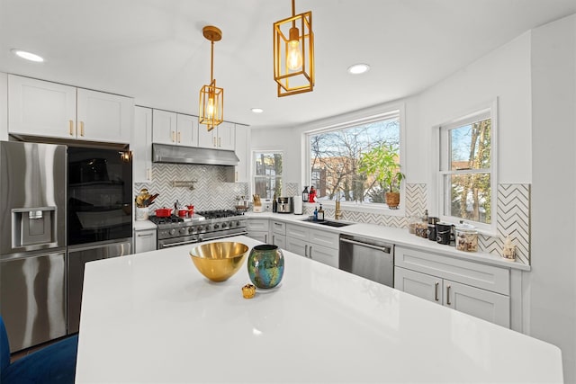 kitchen with pendant lighting, white cabinetry, sink, decorative backsplash, and stainless steel appliances