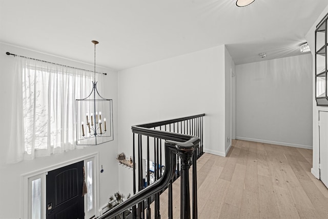 hall featuring a notable chandelier and light hardwood / wood-style floors