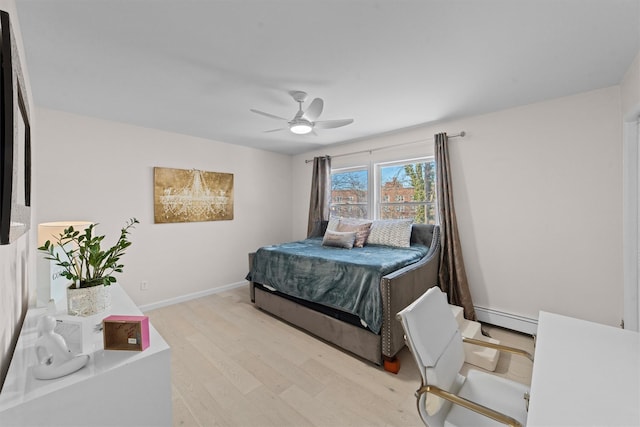 bedroom with a baseboard radiator, light wood-type flooring, and ceiling fan