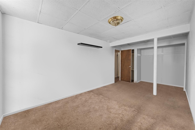 basement featuring carpet and a paneled ceiling