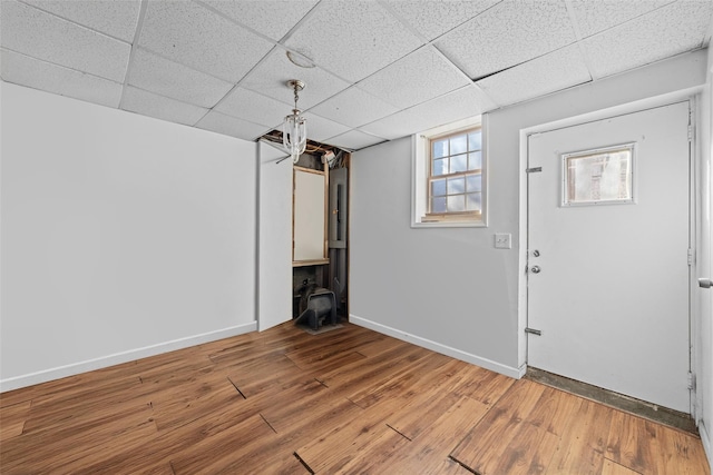 basement with wood-type flooring and a paneled ceiling