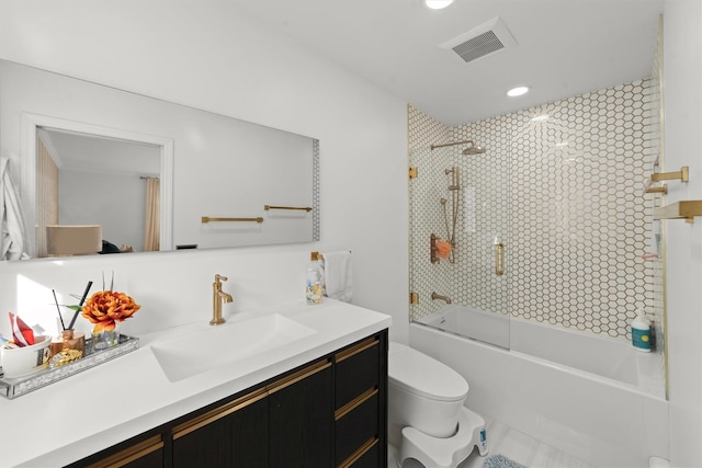 full bathroom with vanity, tiled shower / bath combo, and toilet