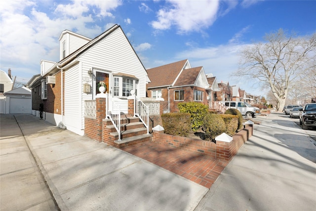 view of front of property featuring a garage, an outbuilding, and an AC wall unit