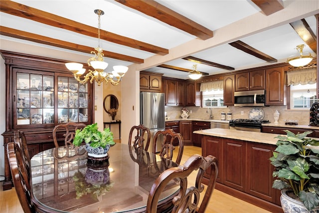 dining space featuring light hardwood / wood-style flooring, beamed ceiling, and an inviting chandelier