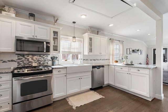 kitchen featuring sink, pendant lighting, stainless steel appliances, light stone countertops, and white cabinets