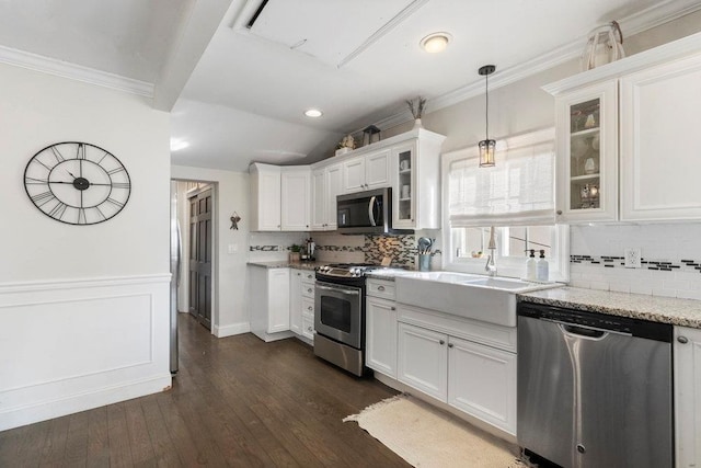 kitchen featuring vaulted ceiling, decorative light fixtures, white cabinetry, light stone counters, and stainless steel appliances