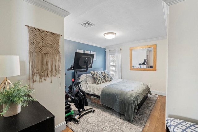 bedroom with hardwood / wood-style floors and crown molding