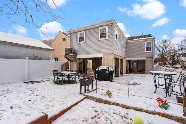 snow covered rear of property featuring cooling unit