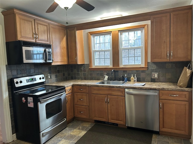 kitchen featuring ceiling fan, sink, backsplash, and stainless steel appliances