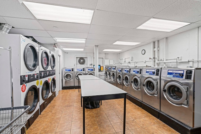 washroom featuring light tile patterned flooring, stacked washer / drying machine, and washing machine and clothes dryer