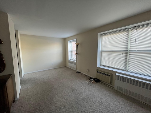 carpeted spare room featuring an AC wall unit and radiator heating unit