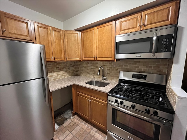 kitchen with backsplash, sink, light stone counters, and stainless steel appliances