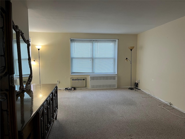 carpeted empty room with radiator heating unit and a wall unit AC