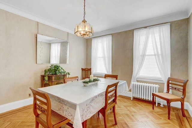 dining room featuring radiator, ornamental molding, a chandelier, and light parquet flooring