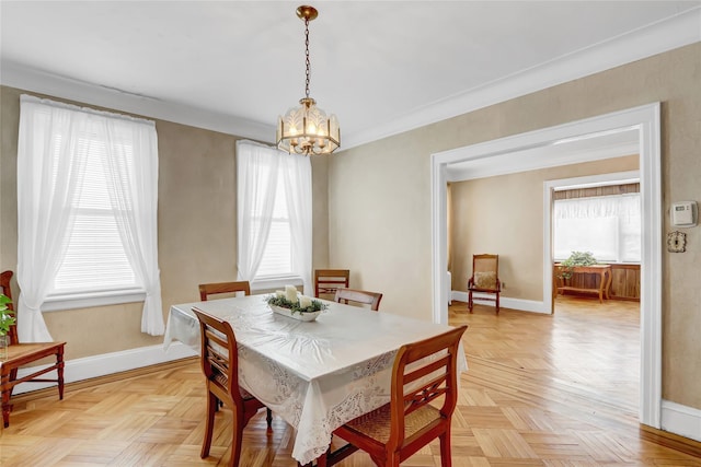 dining room with light parquet flooring, plenty of natural light, and a notable chandelier