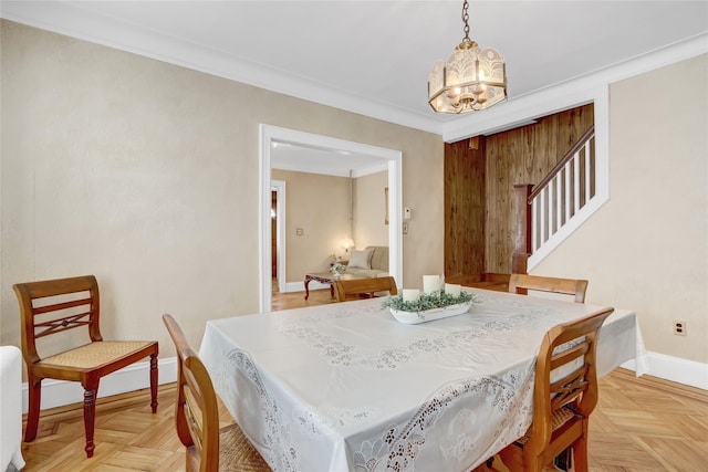 dining room featuring an inviting chandelier, ornamental molding, and light parquet floors