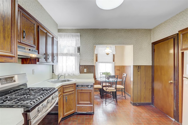 kitchen with white refrigerator, stainless steel range with gas cooktop, and sink