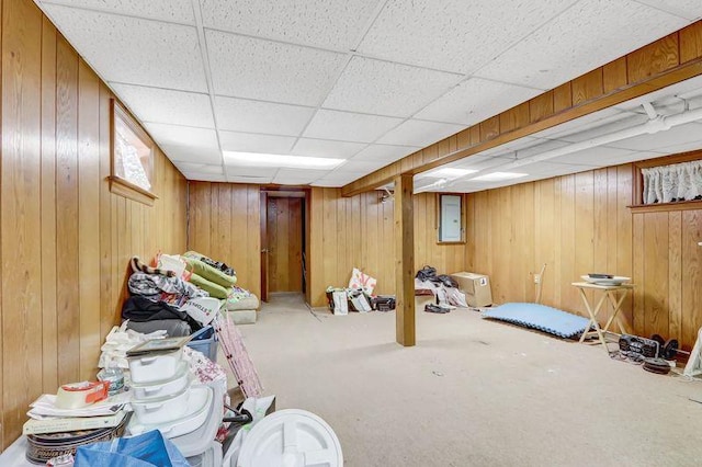 basement featuring electric panel, carpet, and wood walls