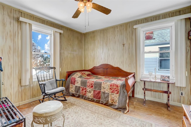 bedroom with wooden walls, hardwood / wood-style floors, and ceiling fan