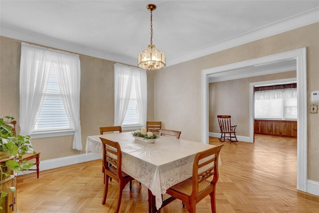 dining area featuring an inviting chandelier, baseboards, and ornamental molding