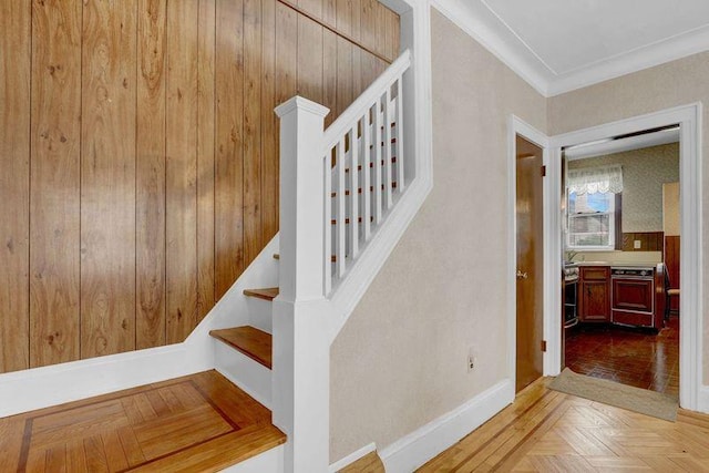 stairway with baseboards and crown molding