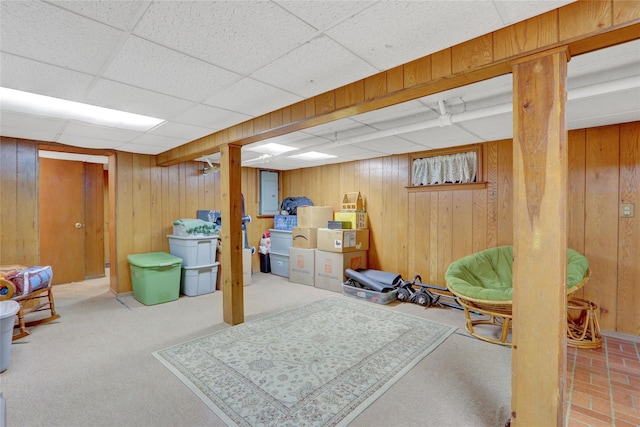 finished below grade area featuring wood walls and a drop ceiling