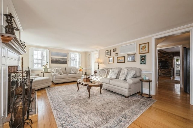 living room featuring ornamental molding, a fireplace, and wood-type flooring