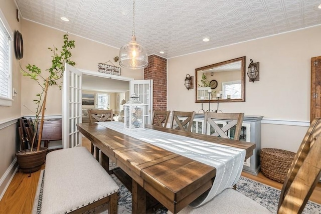 dining space with wood-type flooring and french doors