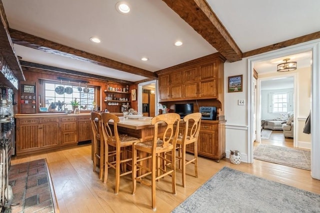 dining room with beam ceiling and light hardwood / wood-style flooring