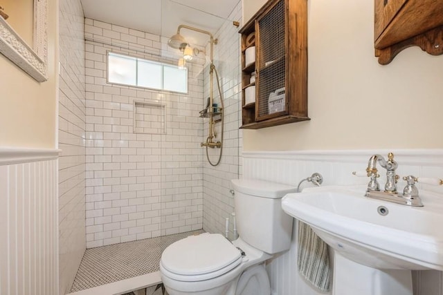 bathroom with sink, toilet, and tiled shower