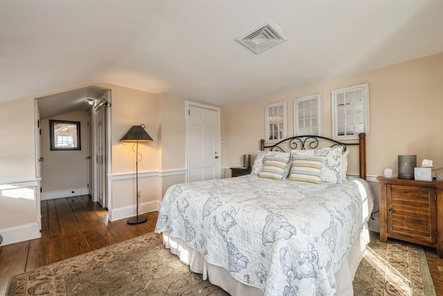 bedroom with dark wood-type flooring and lofted ceiling