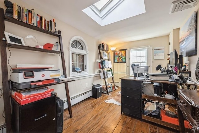 home office with baseboard heating, hardwood / wood-style floors, and vaulted ceiling with skylight